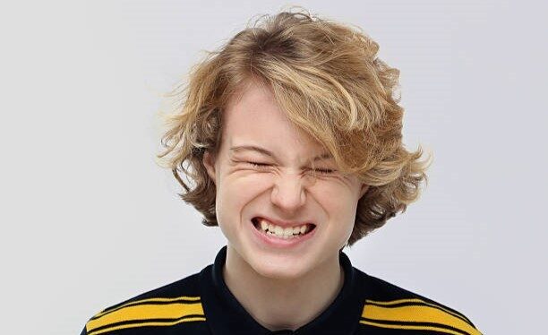 .Angry teenage boy grinding teeth in extreme rage