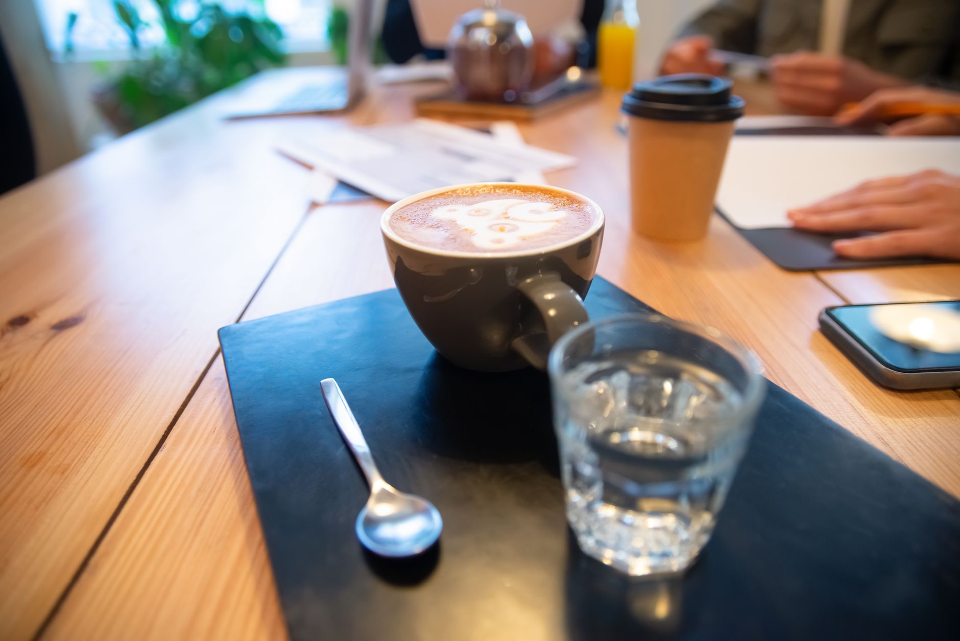 A cup of coffee beside a glass of water on a cafe table